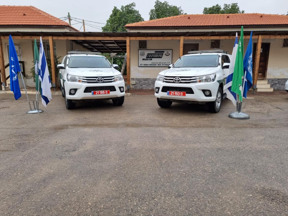 2 רכבי מגב חונים ליד חזית מרכז ההפעלה של מגב ודגלי ישראל, מגב ומשטרה מונפים ברחבה