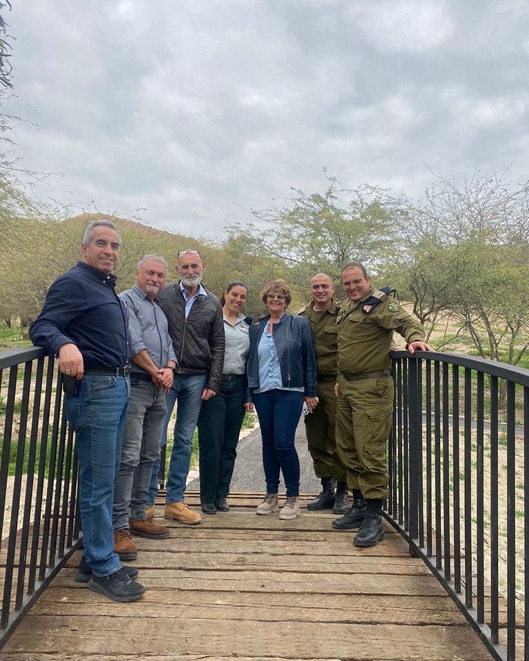ראש המועצה והמזכיר עם אנשי המנהל האזרחי עומדים על הגשרהנגיש כשמאחוריהם עצים במנרחב החניון
