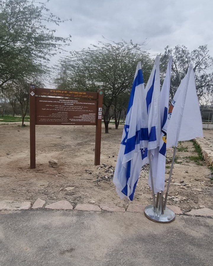 דגלי ישראל ליד שלט של חניון נגיש באנדרטת הבקעה