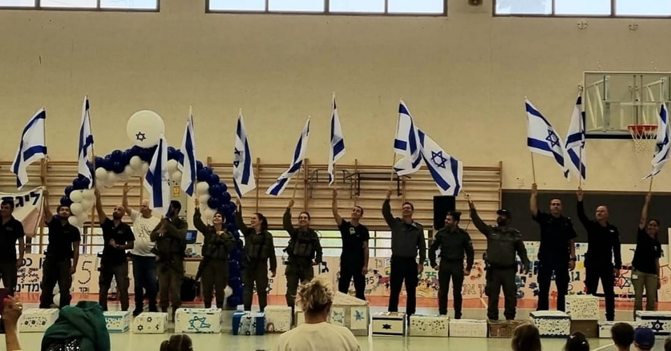 אנשי כוחות הבטחון מניפים דגלים בתוך האולם 