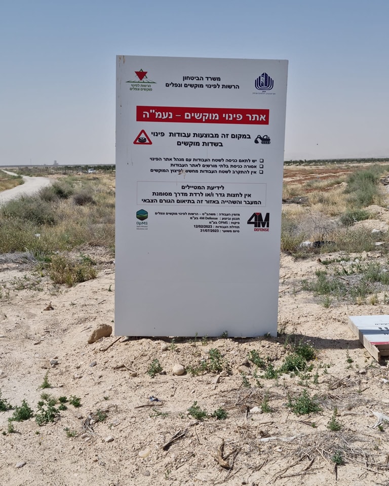 שלט גדול עומד ומשרד הבטחון מודע שבמקום הזה מתבצעות עבודות לפינוי מוקשים. השלט עומד על האדמה 