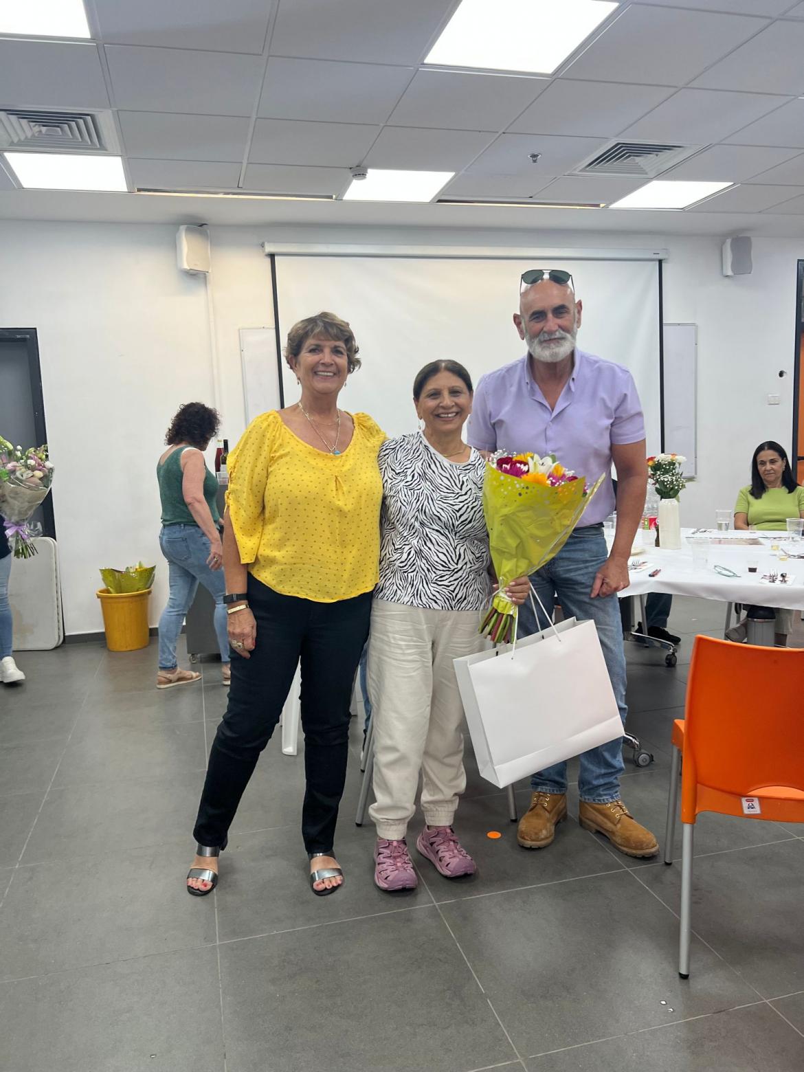 ראש המועצה, מזכיר המועצה והפורשת חבי קיסר שמחזיקה זר פרחים ביד