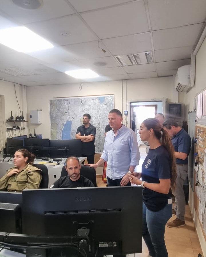 ח"כ אדלשטיין שומע הסברים מקב"טית במוקד חירום. יושבים מנהל המוקד וחיילת ומסתכלים על המסכים
