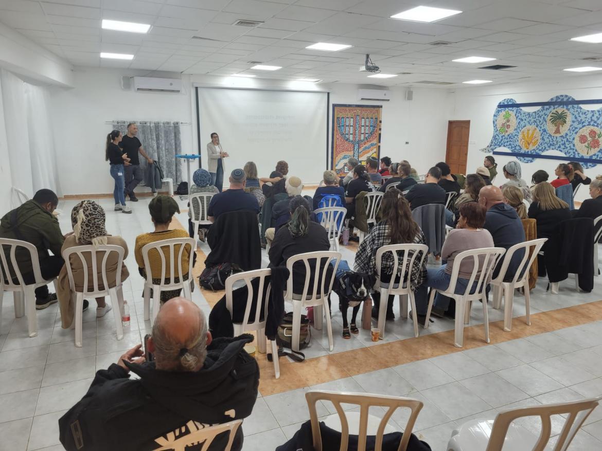 צוותי צחי בישובים יושבים במועדון ומקשיבים לצוות הרפואה של המועצה