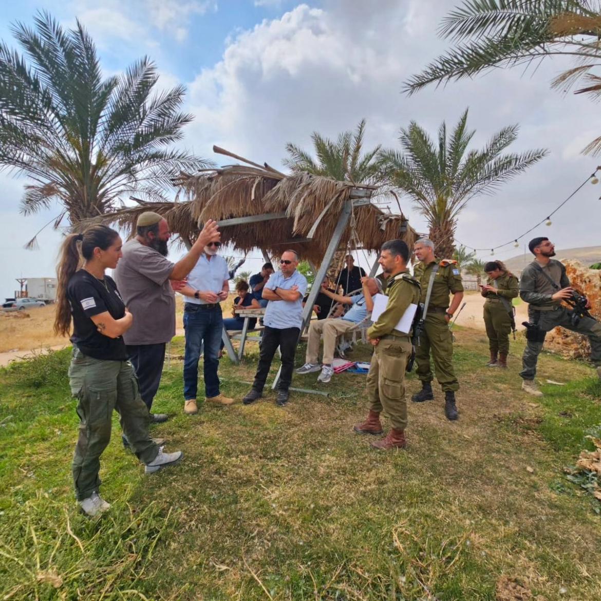אנשי מ. הבטחון, פקע"ר, מועצה עומדים בסככה מתחת לעצי תמר ומקשיב ים להסברים של בעל החווה , ליבי